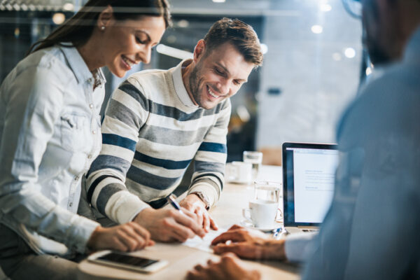 Young happy couple signing remarketing strategies proposal